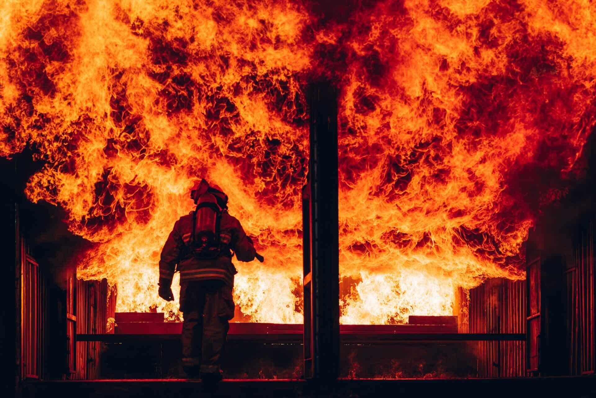 Lone firefighter walking into blaze.